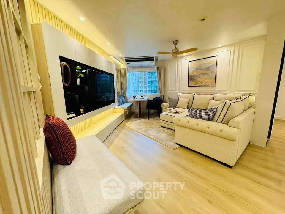 Spacious modern living room with elegant decor and large windows offering a stunning city view.