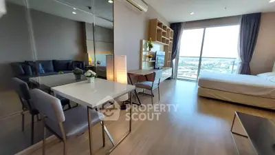 Modern studio apartment with large windows and stylish furnishings