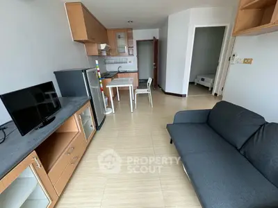 Modern apartment living room with sleek furniture and open kitchen layout.