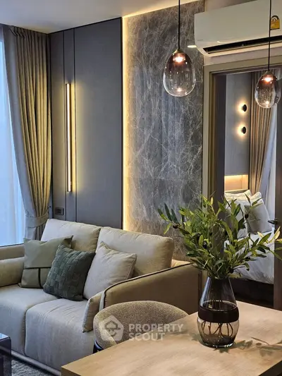 Modern living room with elegant decor, featuring a cozy sofa, stylish lighting, and a glimpse into a chic bedroom.