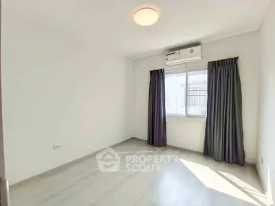 Bright empty bedroom with air conditioning and large window, ideal for customization.