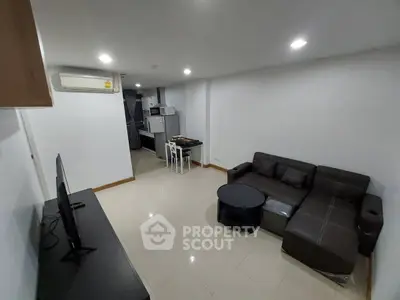 Modern living room with sleek furniture and open kitchen layout in a stylish apartment.