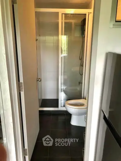 Compact bathroom with shower and modern fixtures in a cozy apartment setting.