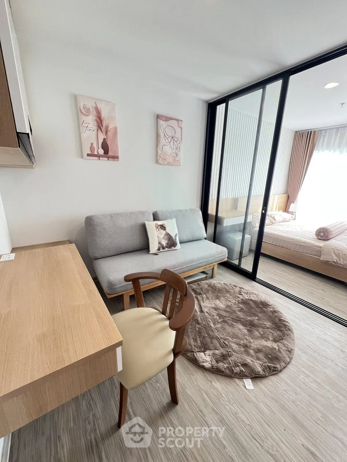 Modern living room with stylish decor and sliding glass doors leading to a cozy bedroom.