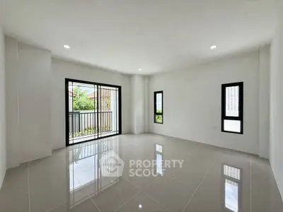 Spacious modern living room with large windows and balcony access, perfect for natural light lovers.
