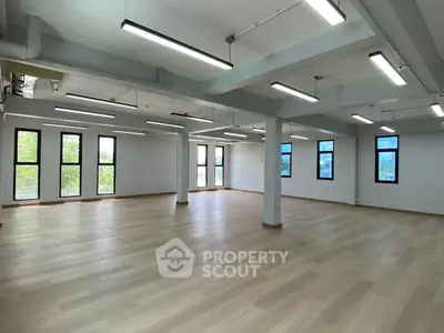 Spacious open-plan interior with large windows and modern lighting, perfect for versatile office or studio use.