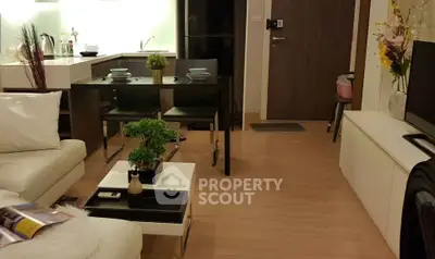 Modern living room with open kitchen and stylish decor in cozy apartment.
