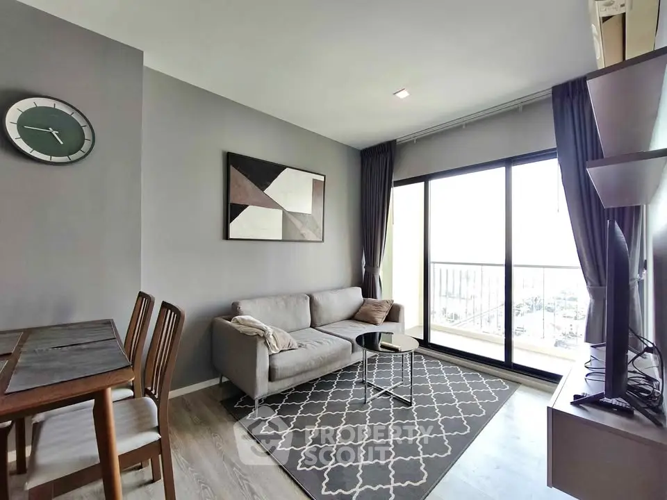 Modern living room with stylish decor and large window offering natural light and city view.