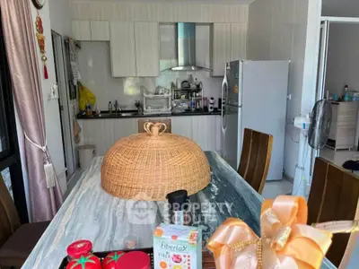 Modern kitchen with marble table and wicker centerpiece, featuring sleek cabinetry and stainless steel appliances.