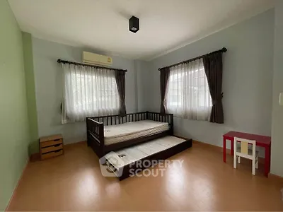 Spacious bedroom with twin beds and natural light, perfect for a cozy retreat.