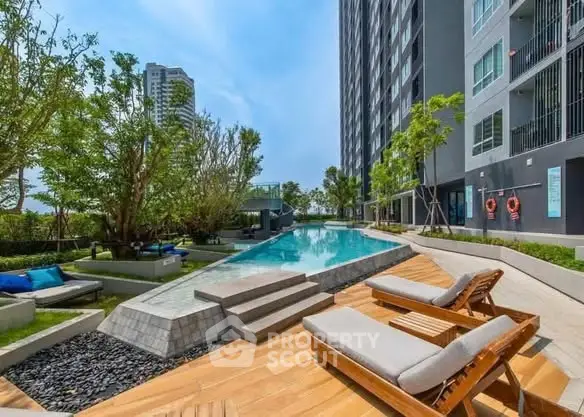 Luxurious condominium poolside with sun loungers and lush greenery