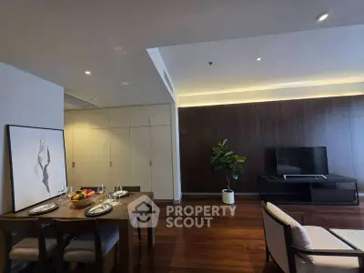 Elegant living room with dining area, modern decor, and wooden flooring in a stylish apartment.