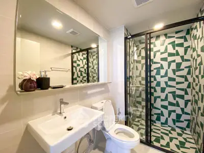 Modern bathroom with geometric shower tiles and sleek fixtures