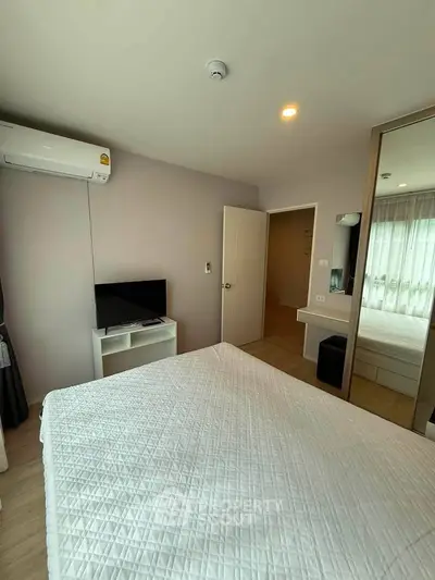 Modern bedroom with air conditioning and TV, featuring a cozy bed and stylish decor.