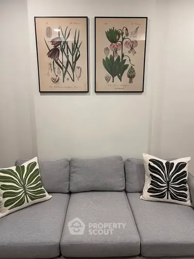 Stylish living room with modern gray sofa and botanical wall art, perfect for contemporary home decor.