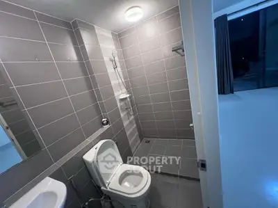 Modern bathroom with sleek gray tiles and contemporary fixtures in a stylish home.