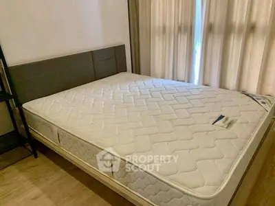 Spacious bedroom with large bed and natural light from window, ideal for comfort and relaxation.