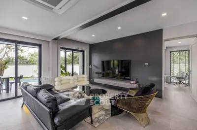 Modern living room with stylish furniture and large windows overlooking garden