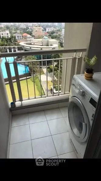 Charming balcony with washing machine and pool view, perfect for urban living.