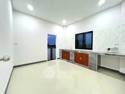 Modern minimalist kitchen with sleek cabinetry and large window