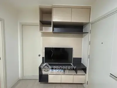 Modern living room with sleek TV unit and ample storage space.