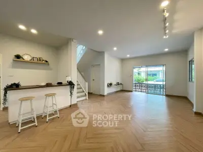 Spacious open-plan living room with modern kitchen and wooden flooring