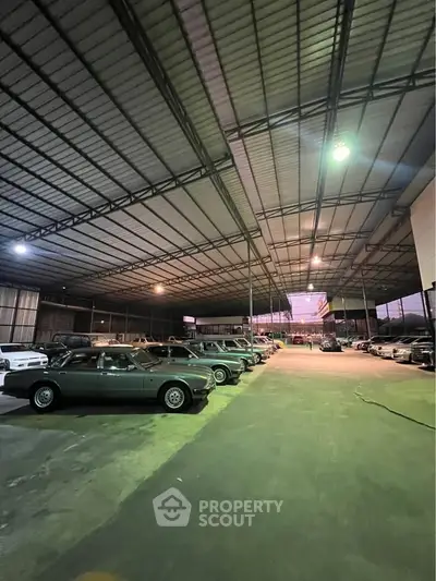 Spacious warehouse with ample parking space and high ceilings, ideal for storage or commercial use.