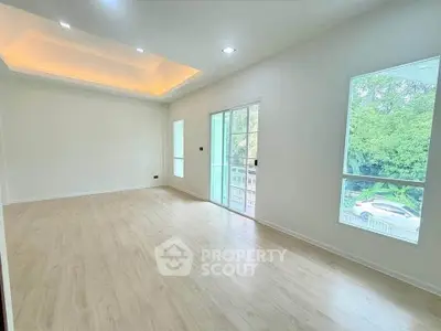 Spacious and bright living room with large windows and modern lighting