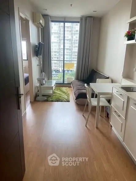 Modern living room with large window and stylish furniture in a high-rise apartment.