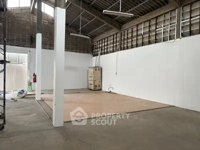 Spacious industrial warehouse interior with high ceilings and concrete floors.
