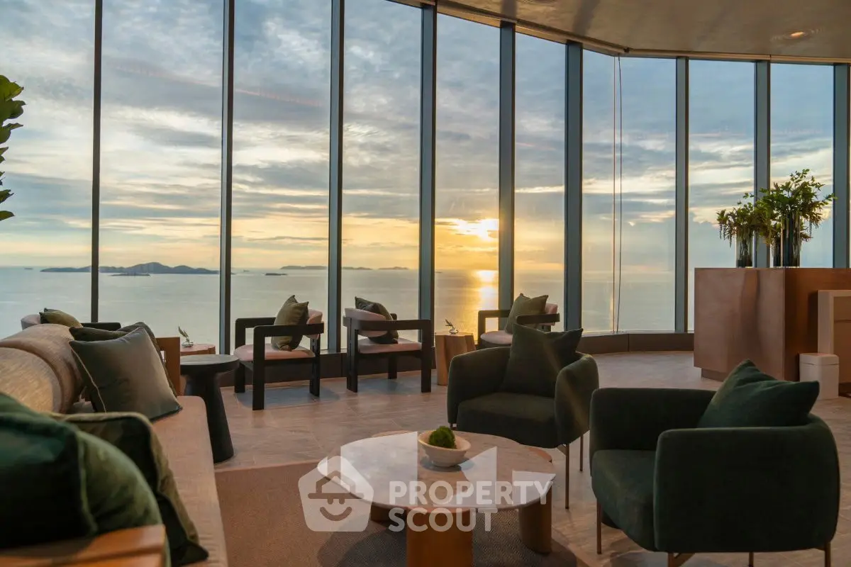 Luxurious living room with panoramic ocean view and elegant furnishings, perfect for sunset relaxation.