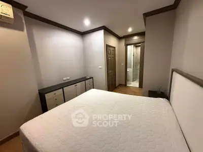 Spacious bedroom with modern decor and ensuite bathroom in a stylish apartment.