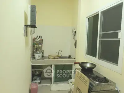Compact kitchen with gas stove and window, featuring efficient storage solutions.