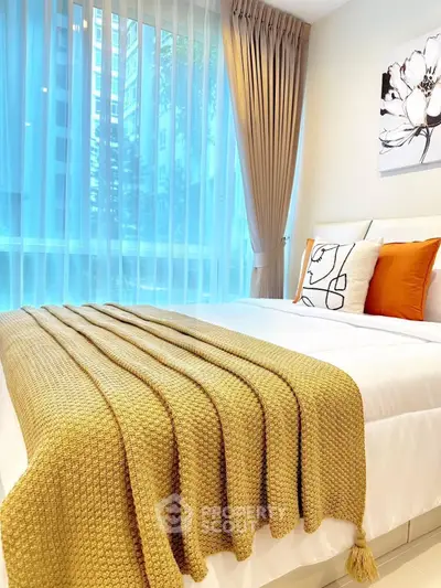 Bright and cozy bedroom with modern decor and large window view.