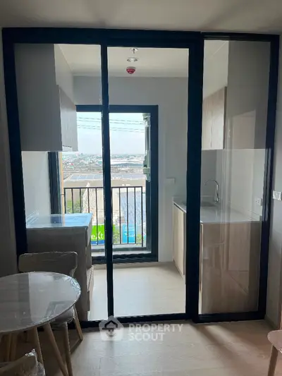 Modern apartment with glass doors leading to a compact balcony and city view