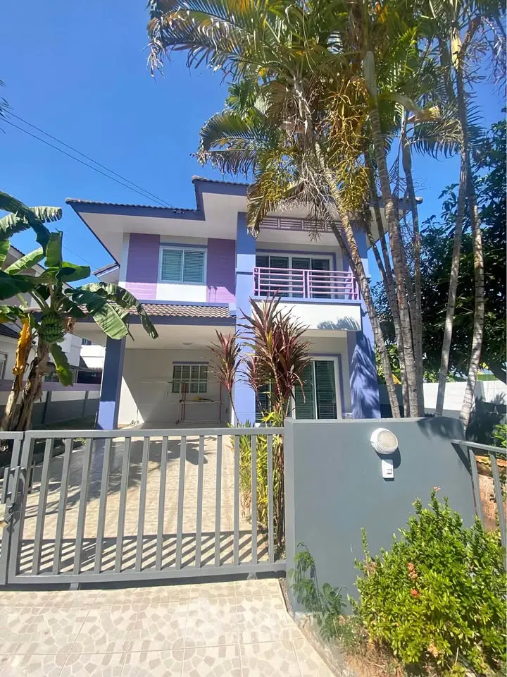 Charming two-story purple house with lush garden and gated entrance