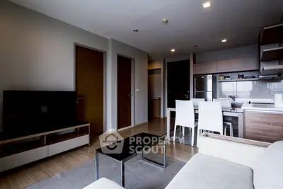 Modern living room with open kitchen and sleek furniture in a stylish apartment.