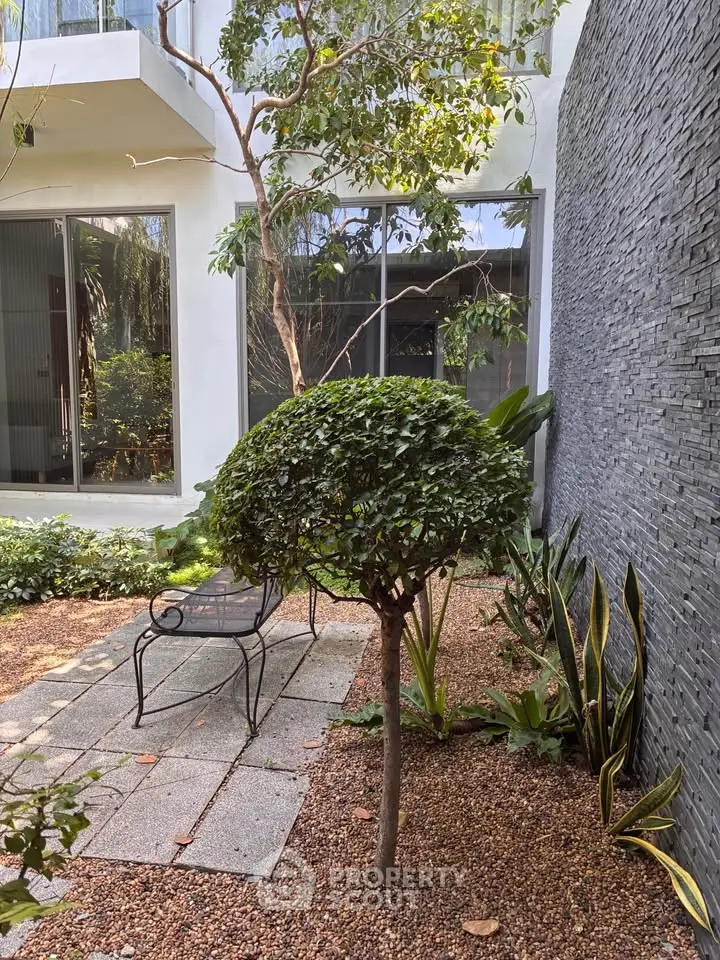 Charming garden patio with lush greenery and modern design, perfect for relaxation and outdoor enjoyment.