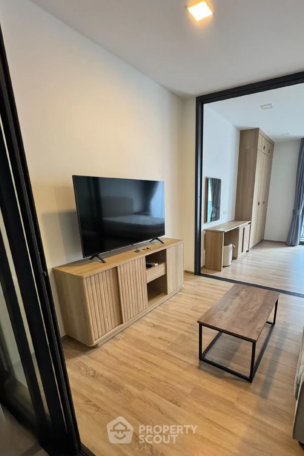 Modern living room with sleek TV setup and wooden flooring