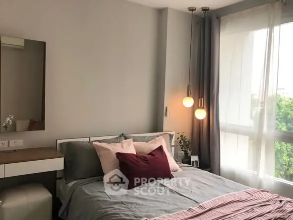 Cozy bedroom with modern decor and large window for natural light.