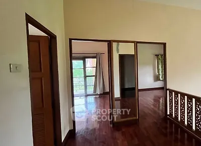 Spacious interior with wooden flooring and large windows offering natural light.