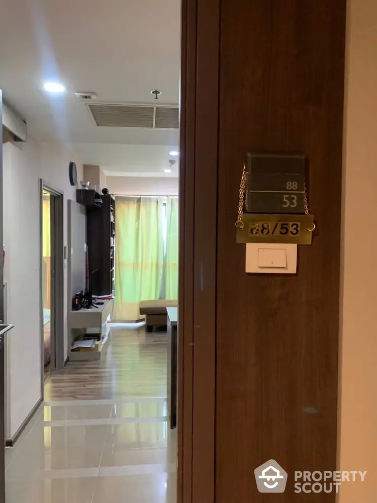 Inviting modern apartment interior showcasing a sleek hallway leading to a cozy living space with ample natural light and contemporary furnishings.