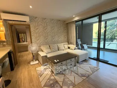 Spacious living room with modern decor and large balcony access, perfect for relaxation and entertaining.