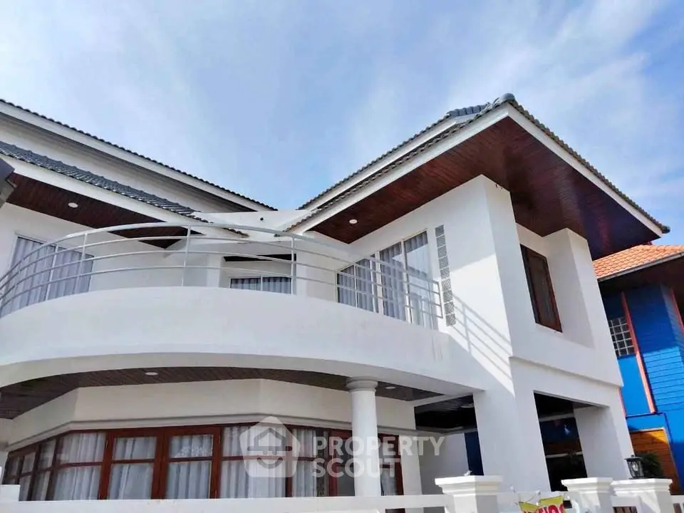 Stunning modern house exterior with elegant balcony and sleek architectural design.