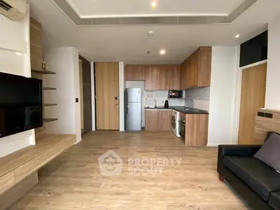 Modern open-plan living room with sleek kitchen and wooden flooring