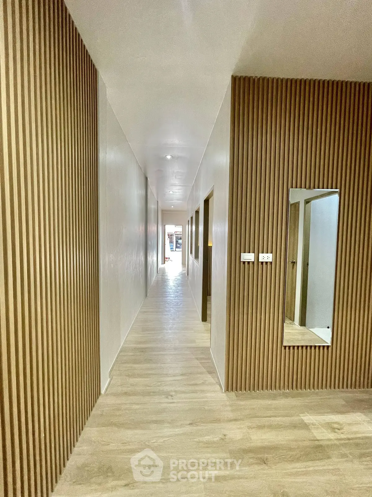 Modern hallway with wooden paneling and sleek design in a contemporary building.