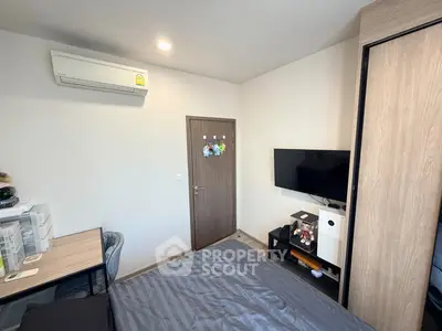 Modern bedroom with air conditioning and wall-mounted TV, featuring sleek furniture and ample storage space.