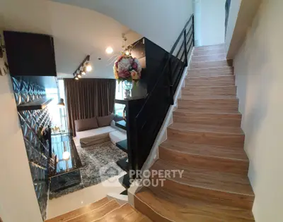 Modern duplex living room with stylish decor and wooden staircase