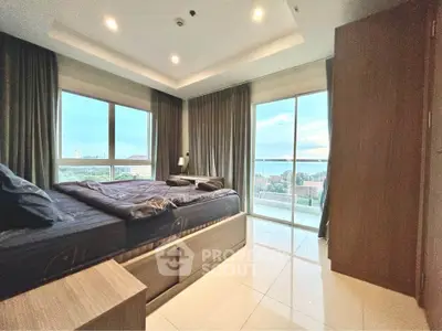 Luxurious bedroom with panoramic windows and stunning view in modern high-rise apartment.