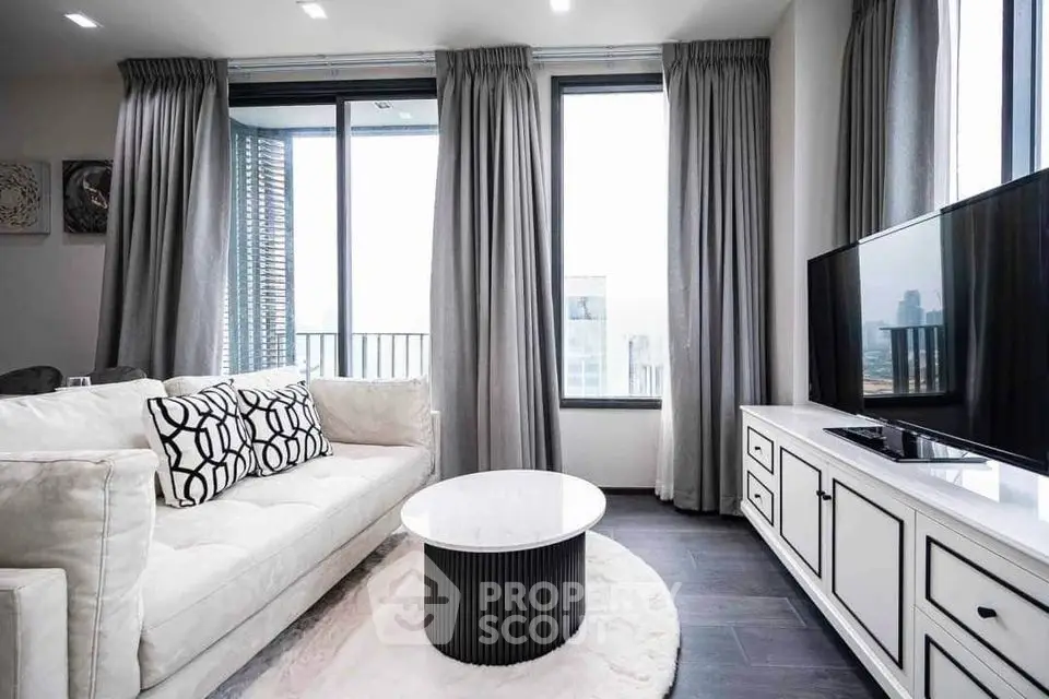 Luxurious modern living room with elegant decor and city view, featuring plush sofa and sleek entertainment unit.